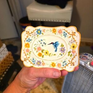 Decorative trinket dish or soap dish featuring a hummingbird and floral design. 